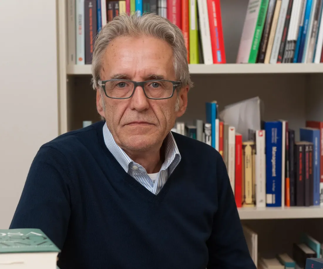 Klaus Kufeld vor seinem Bücherregal